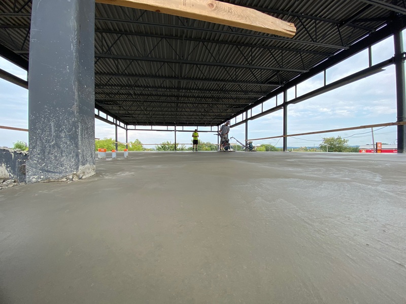 Smooth concrete slab inside a steel-framed commercial building
